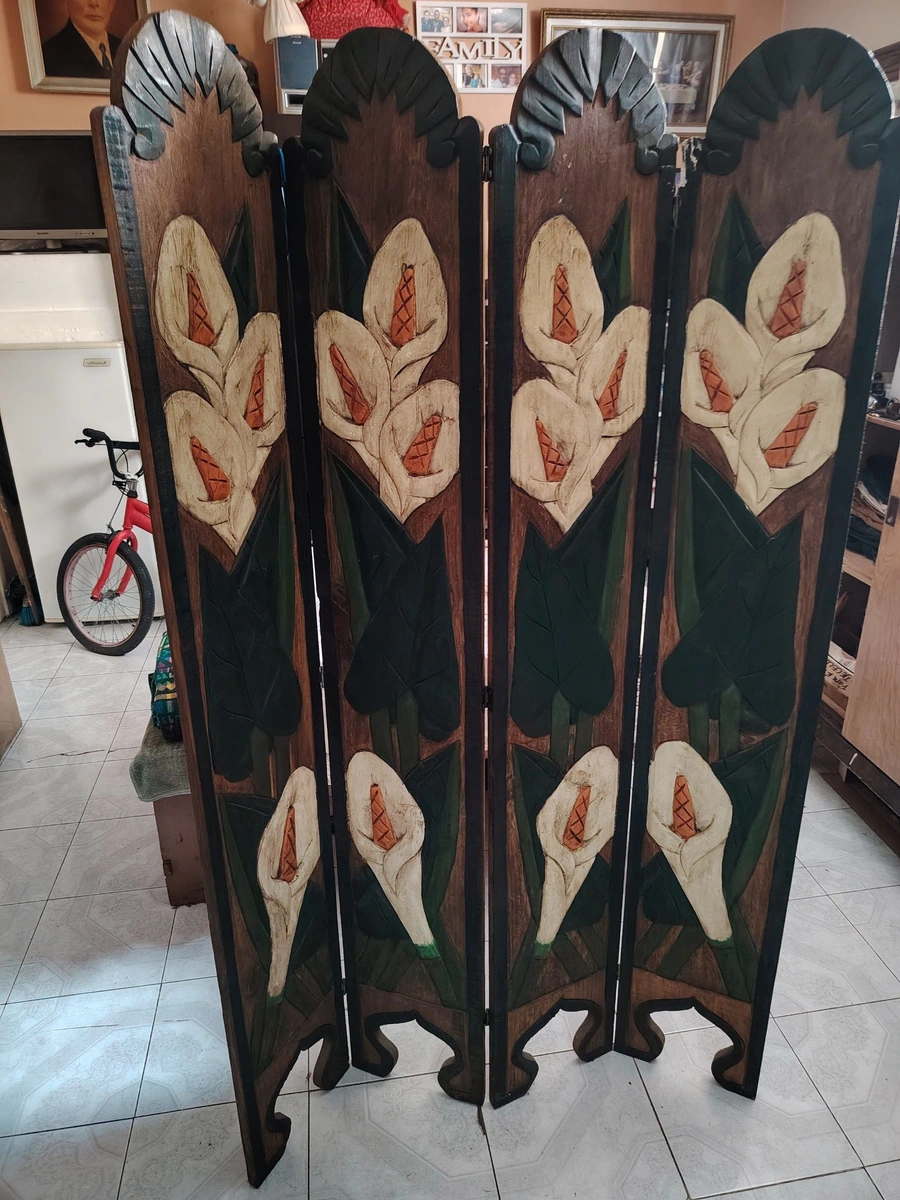 Este biombo artesanal de madera cuenta con cuatro paneles y está tallado con diseños de flores de alcatraz