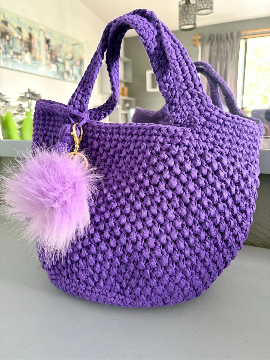 Bolso tejido a mano color morado con accesorios tejidos y borla de peluche